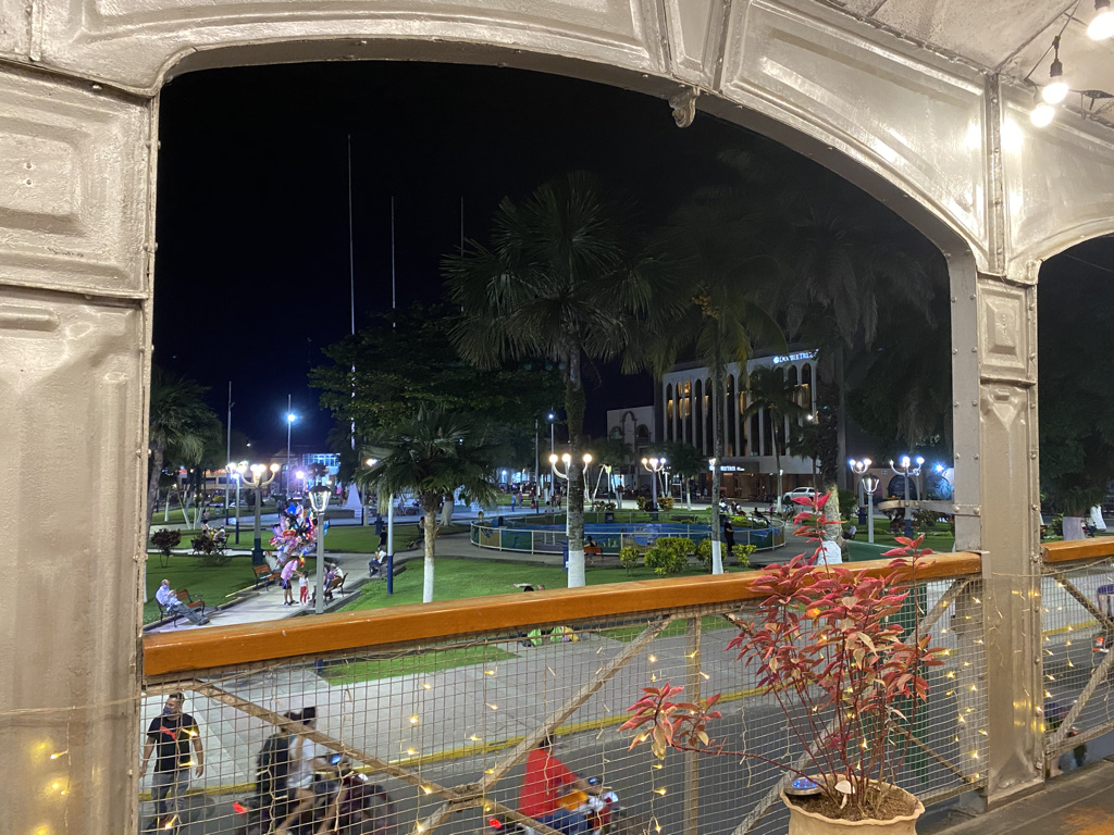 The Plaza de Armas of Iquitos at night, seen through the ironwork of Casa de Fierro