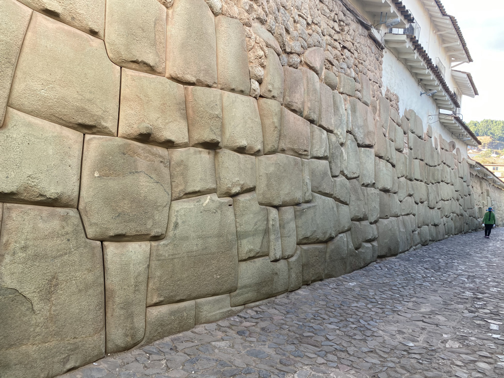 Massive Incan stone walls lining a cobblestone street in Cusco